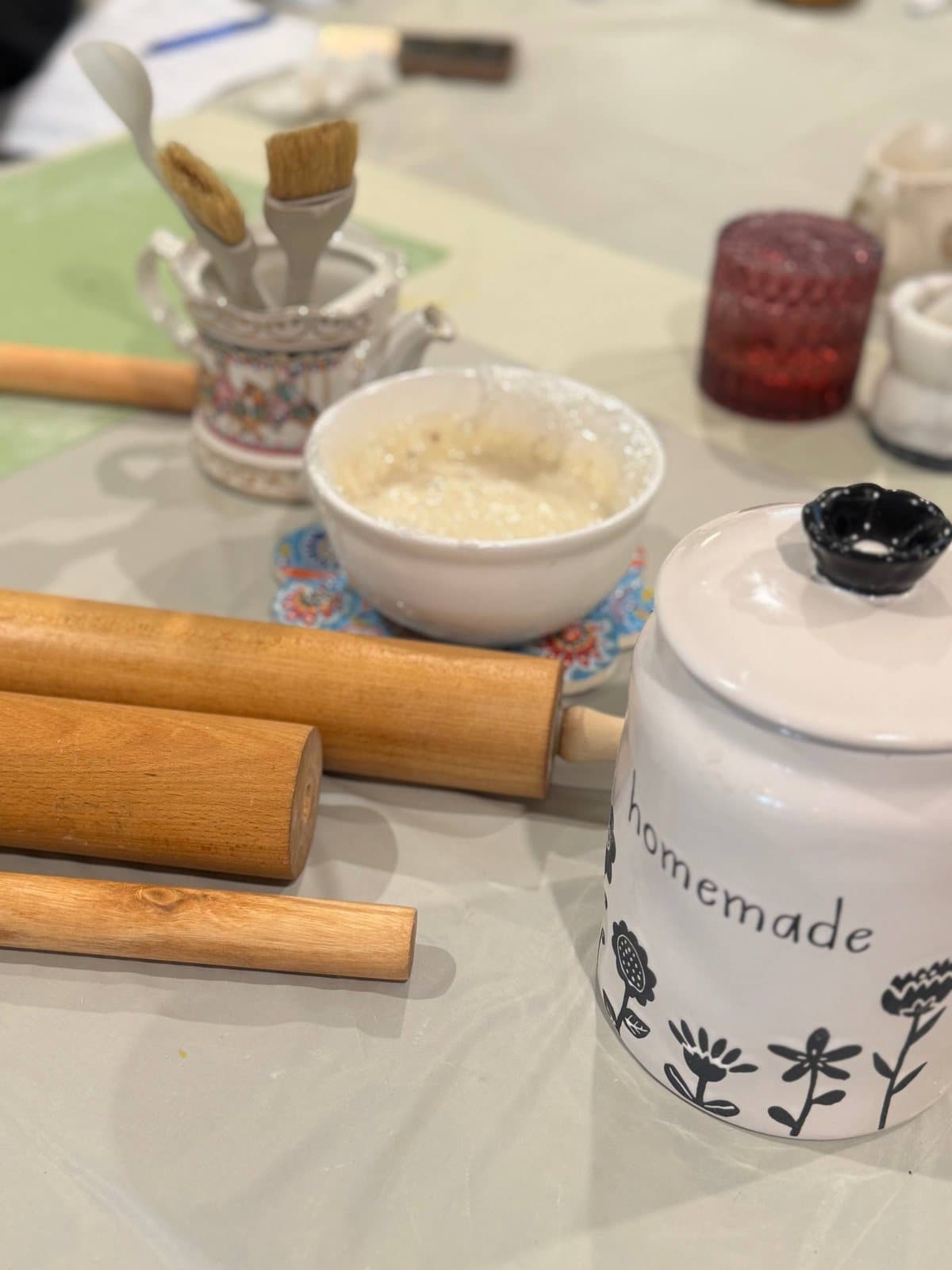 Rolling pins, pastry brushes and a bowl of pastry cream on the workshop table