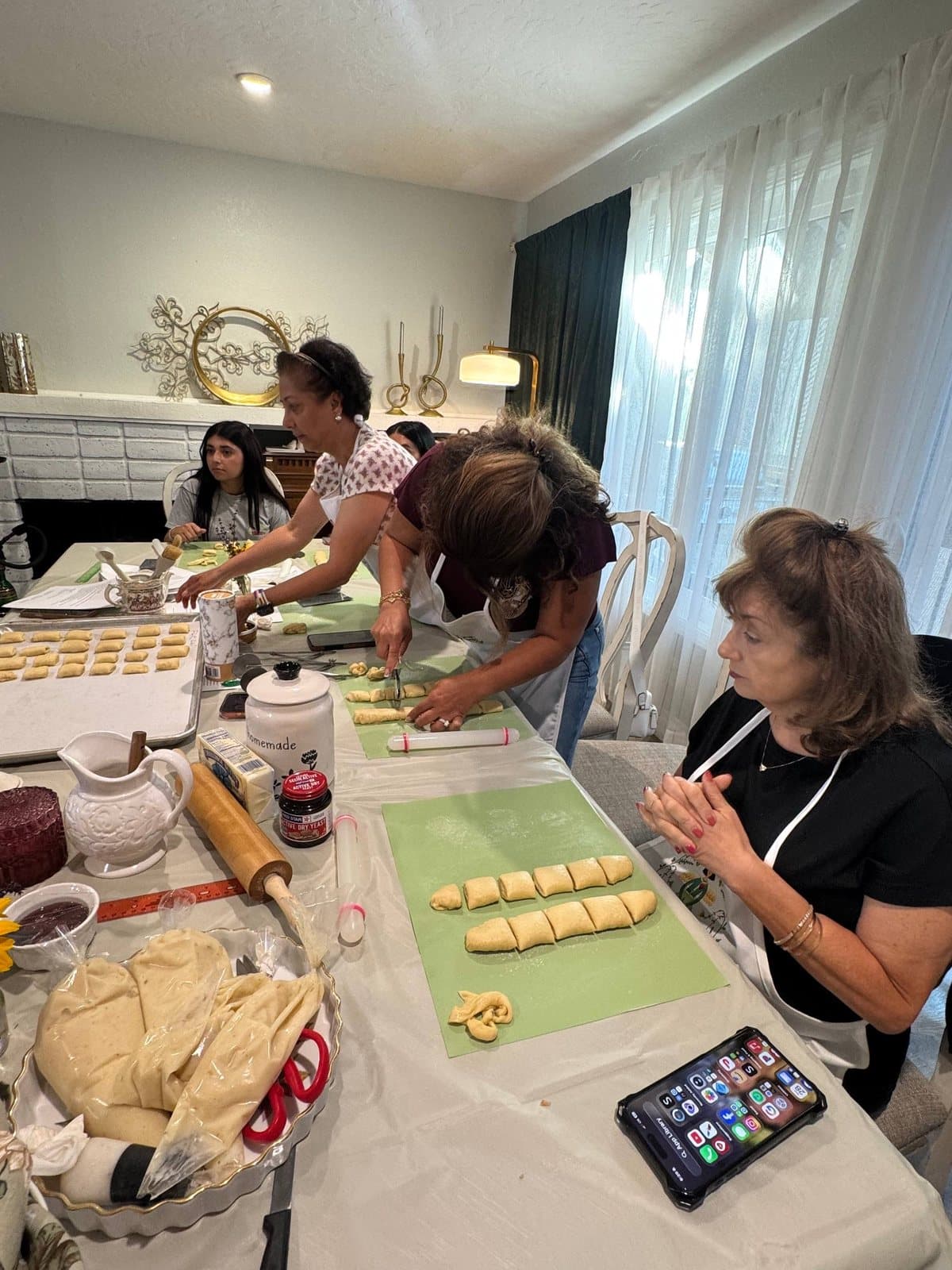 Guests shaping cut pastry along the length of the workshop table